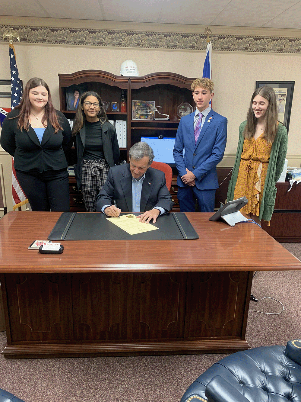 Bardstown High School students stand behind the mayor as he signs a proclamation